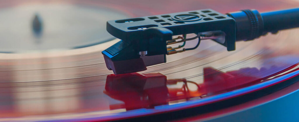 Close-up image of vinyl record player cartridge and needle